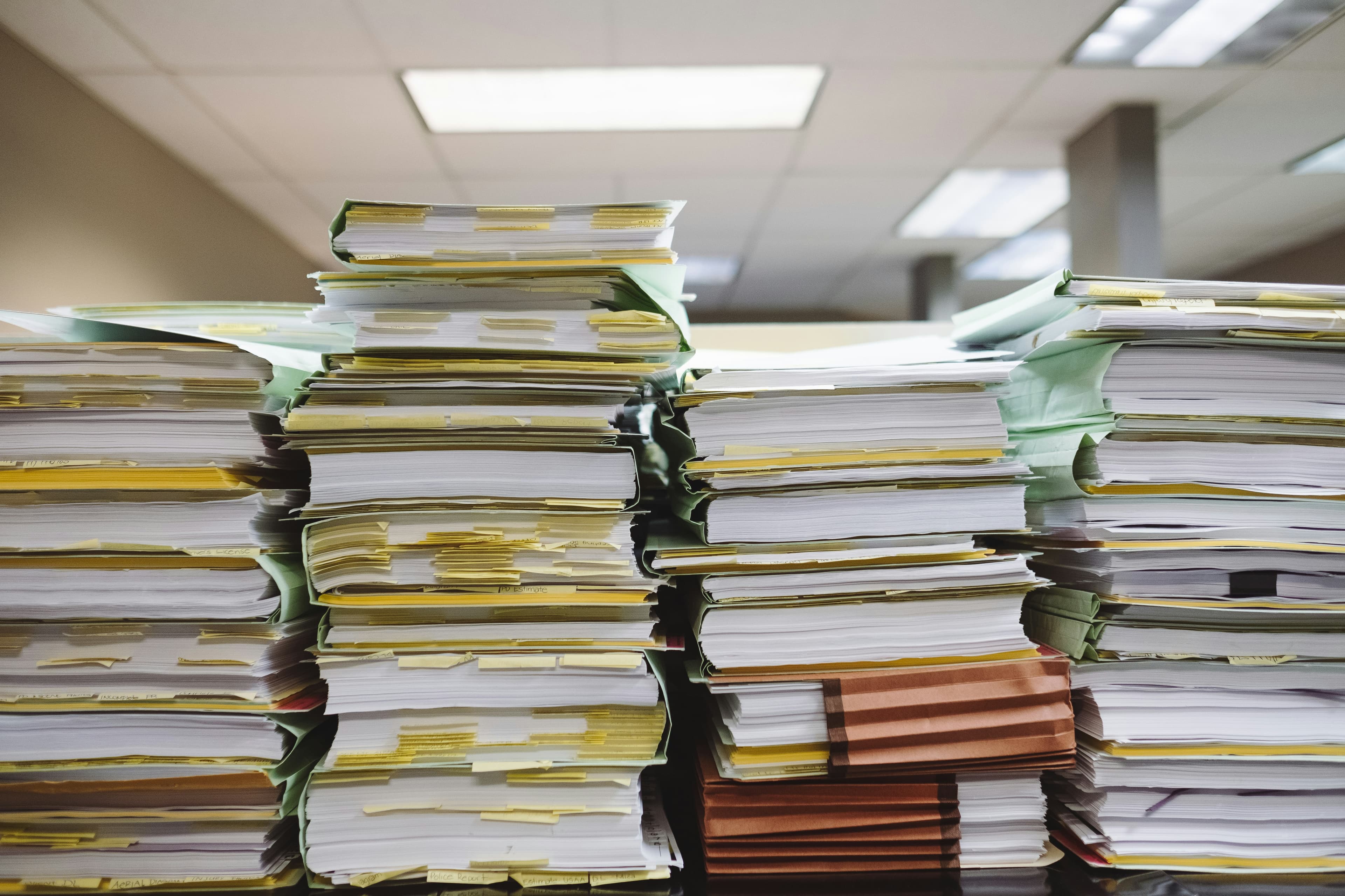 Stacks of tabbed case files on a desk in an office